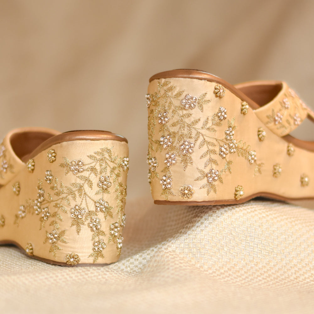 Ivory platform wedges featuring crossover straps with delicate floral embroidery
