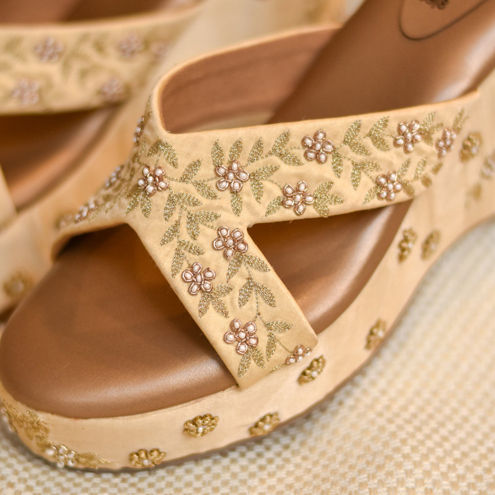 Hand-embroidered Golden wedges with crossover straps and floral threadwork

