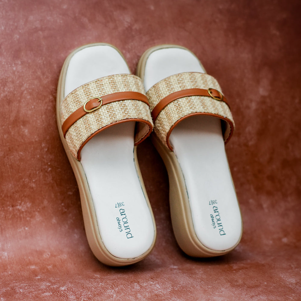 A pair of women's sliders with jute woven beige straps, brown leather trim, and a beige platform sole