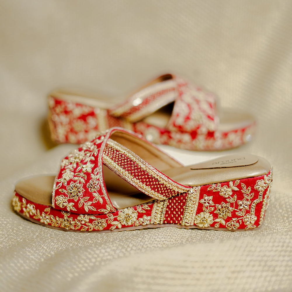 Red occasion wedges with gold embellishments, a cushioned footbed, and a wedge heel.