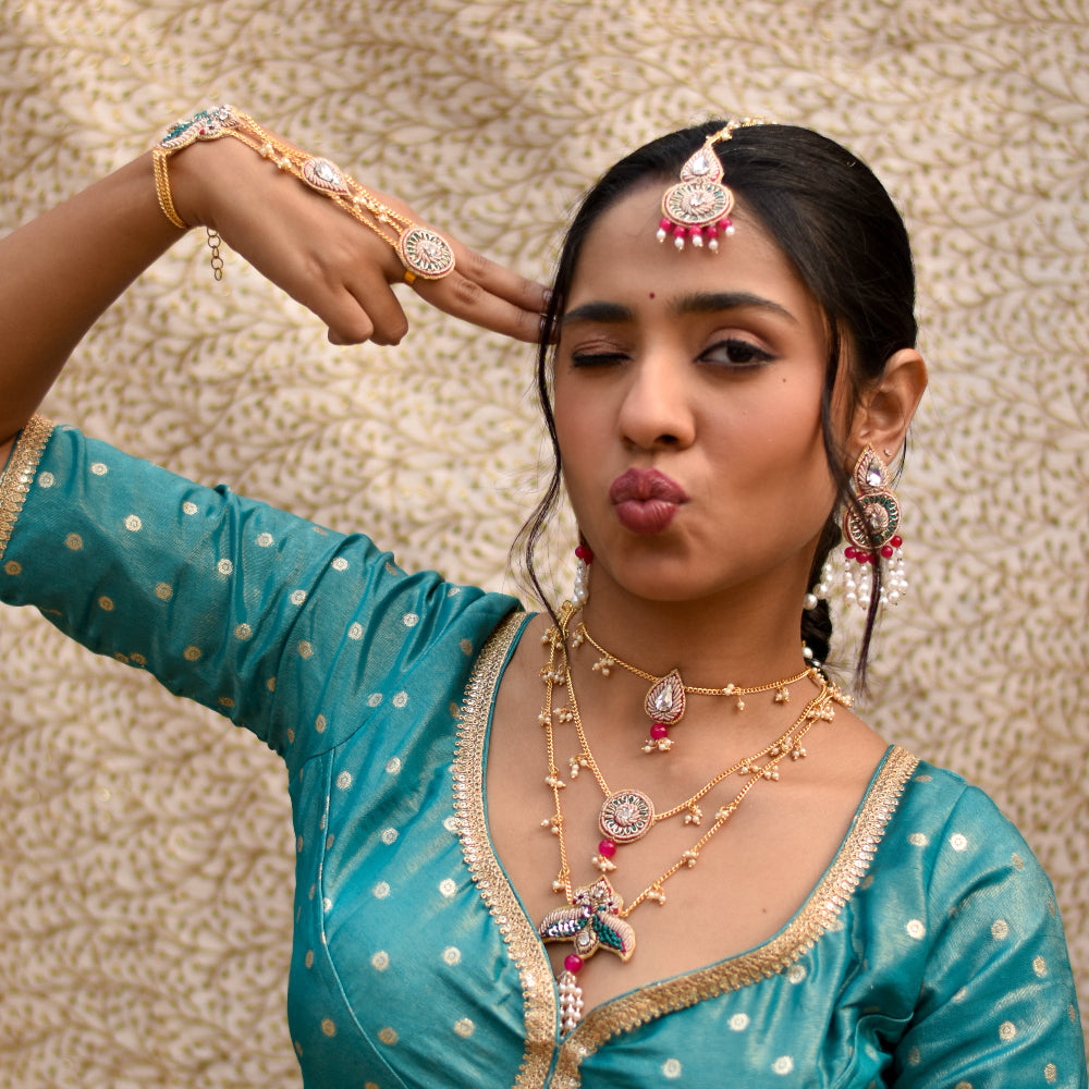 A bride striking a fun pose in her haldi outfit and beaded jewellery accesories