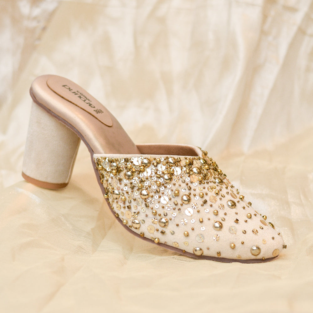 Women's ivory bridal mule heels with intricate gold-toned handwork.
