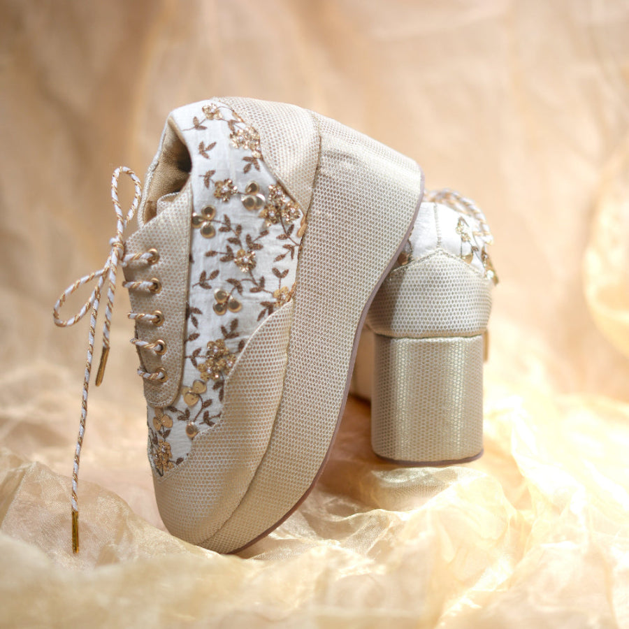 Festive lace-up wedge sneakers featuring gold floral motifs on an elegant ivory base