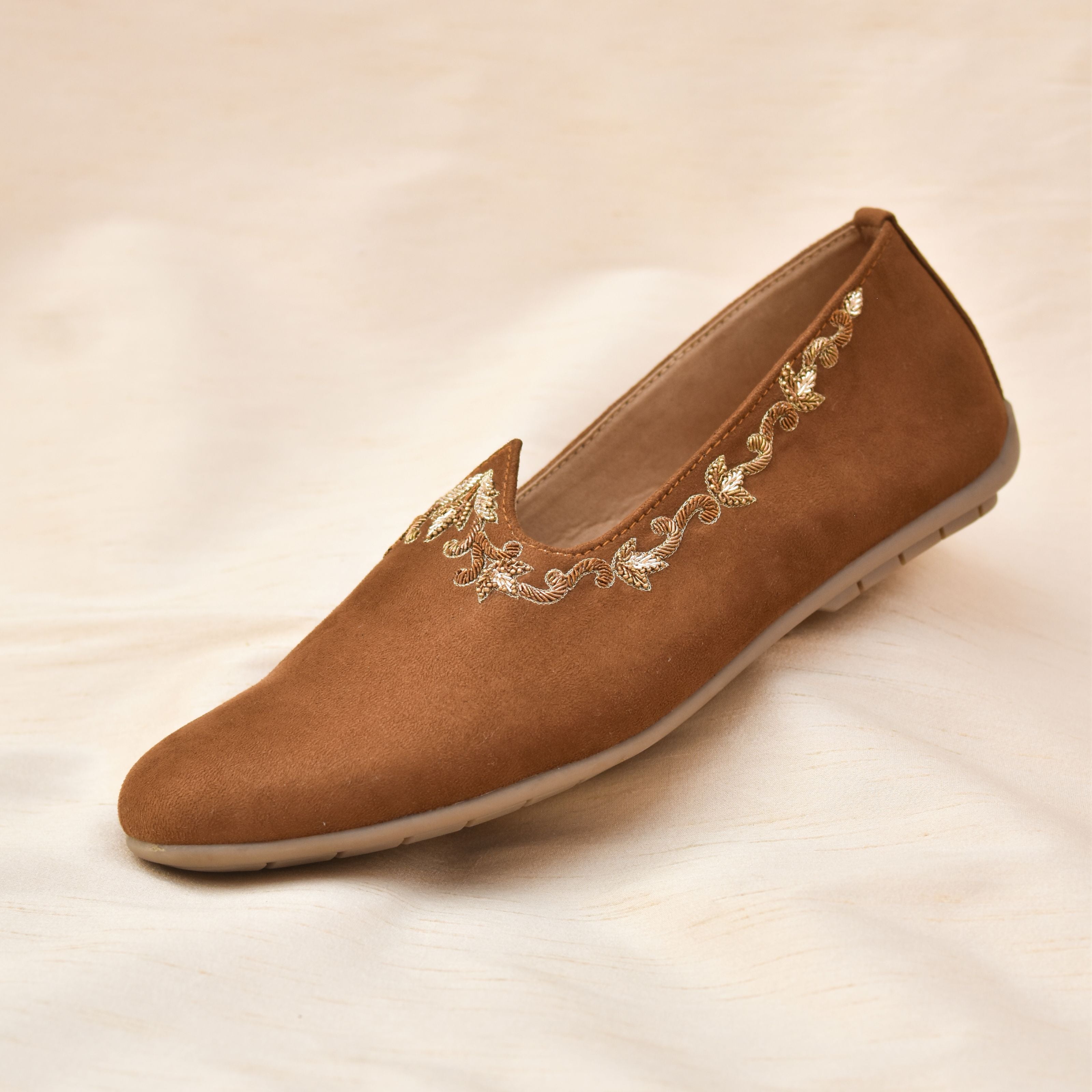 Tan slip-on shoes with soft velvet texture and delicate gold leaf embroidery.
