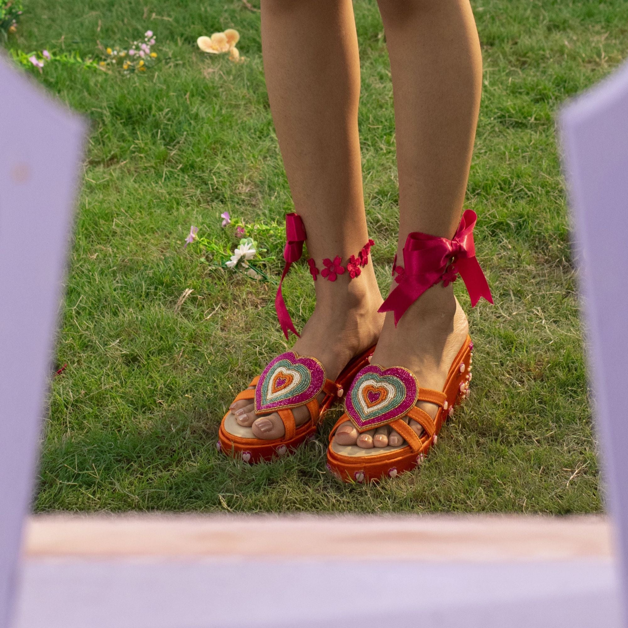 Vibrant orange sandals with playful heart detail