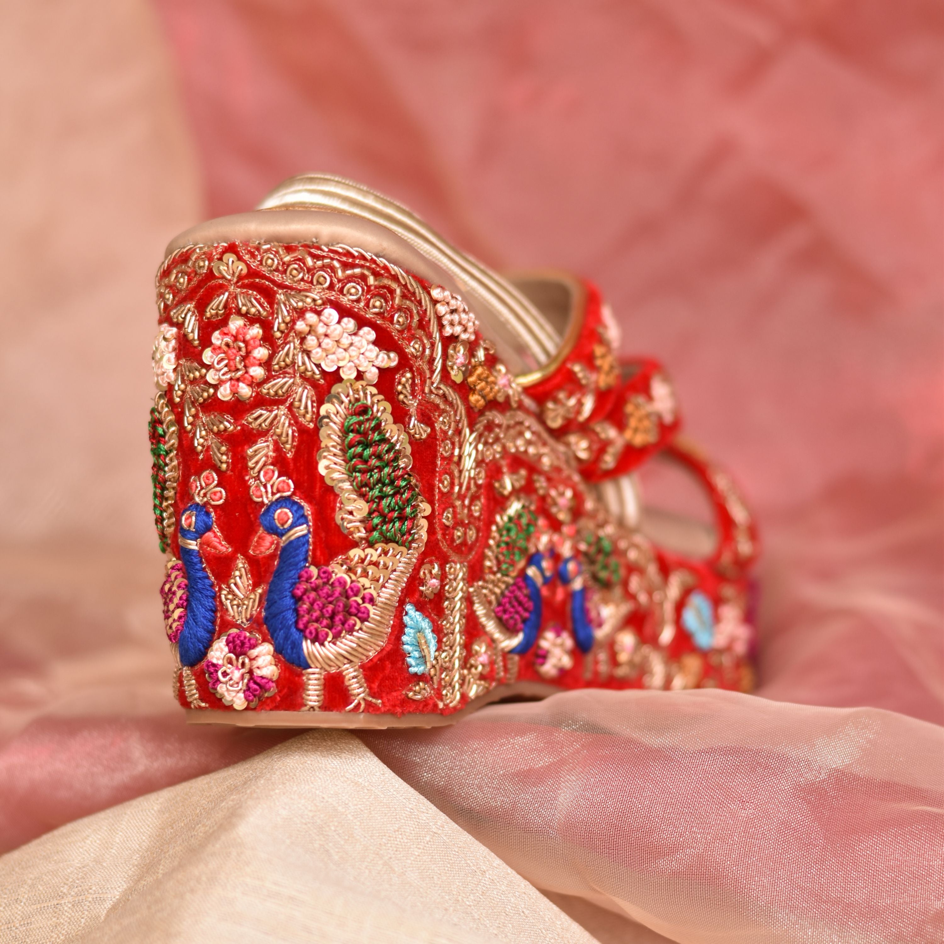 Traditional Indian wedge sandals with embroidered peacock motif and royal arches.