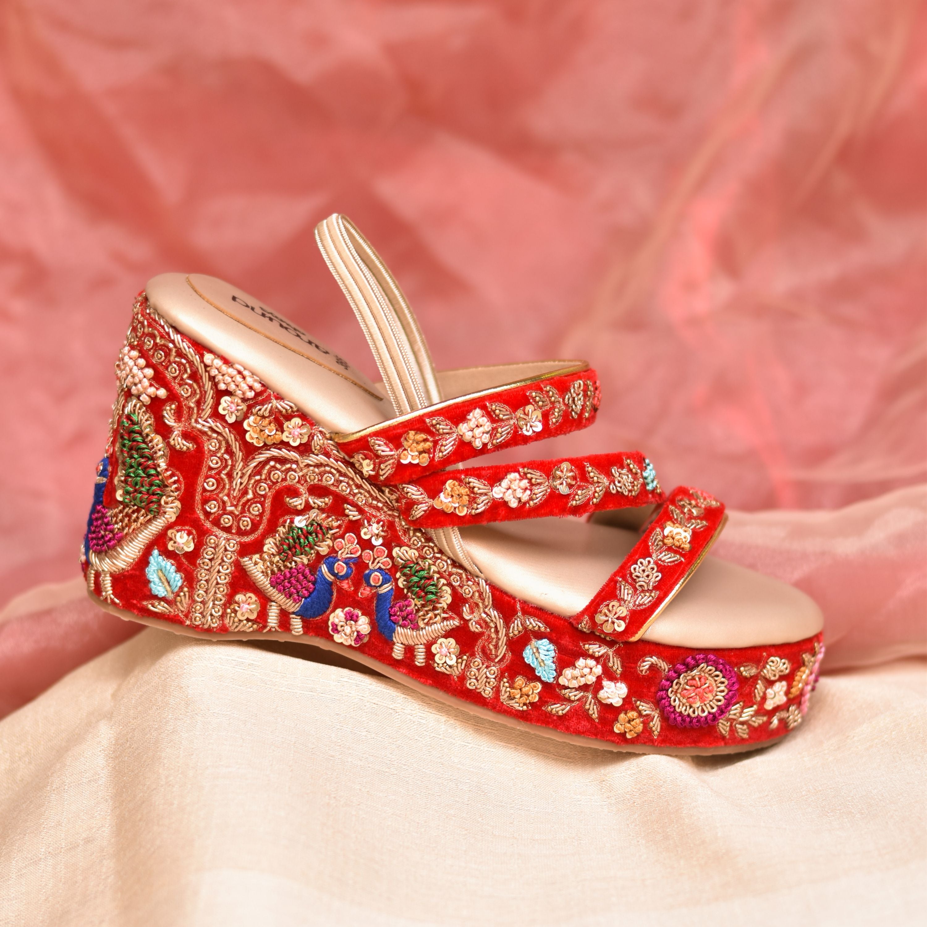 Designer red wedges with detailed gold and multicolour thread motifs.
