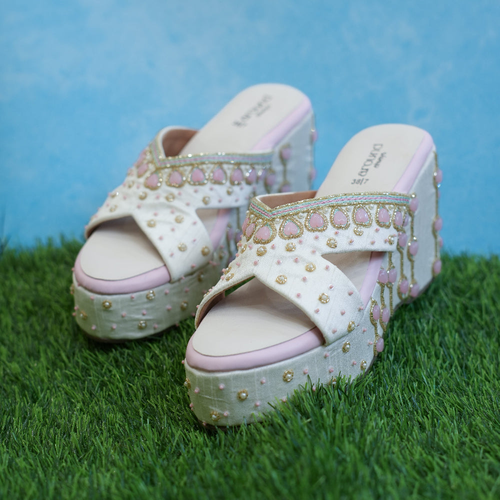 Ivory platform sandals with pink heart detailing and gold motifs
