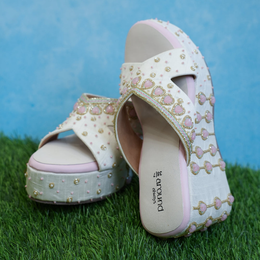 Ivory festive sandals featuring pink heart-shaped stone detailing
