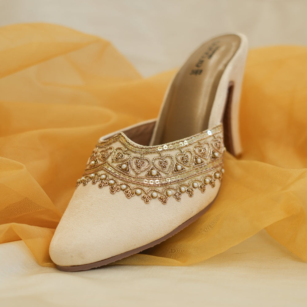 Champagne pointed-toe mules with intricate gold embroidery
