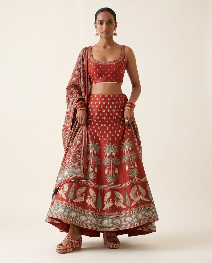 A young Indian woman wearing a couture designer lehenga paired with red wedges from Around Always