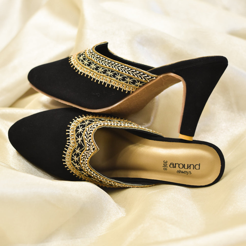 Black velvet mules with metallic handwork and pointed front.