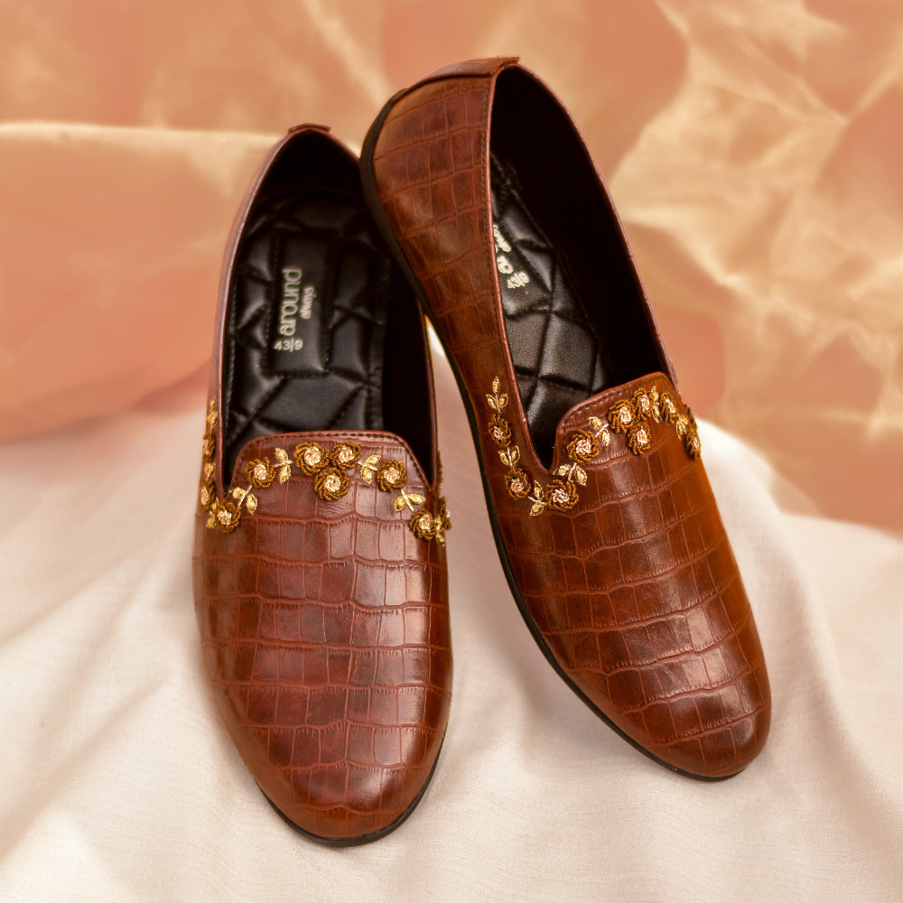 Rich brown leather loafer with embossed finish and delicate hand-embroidered accents