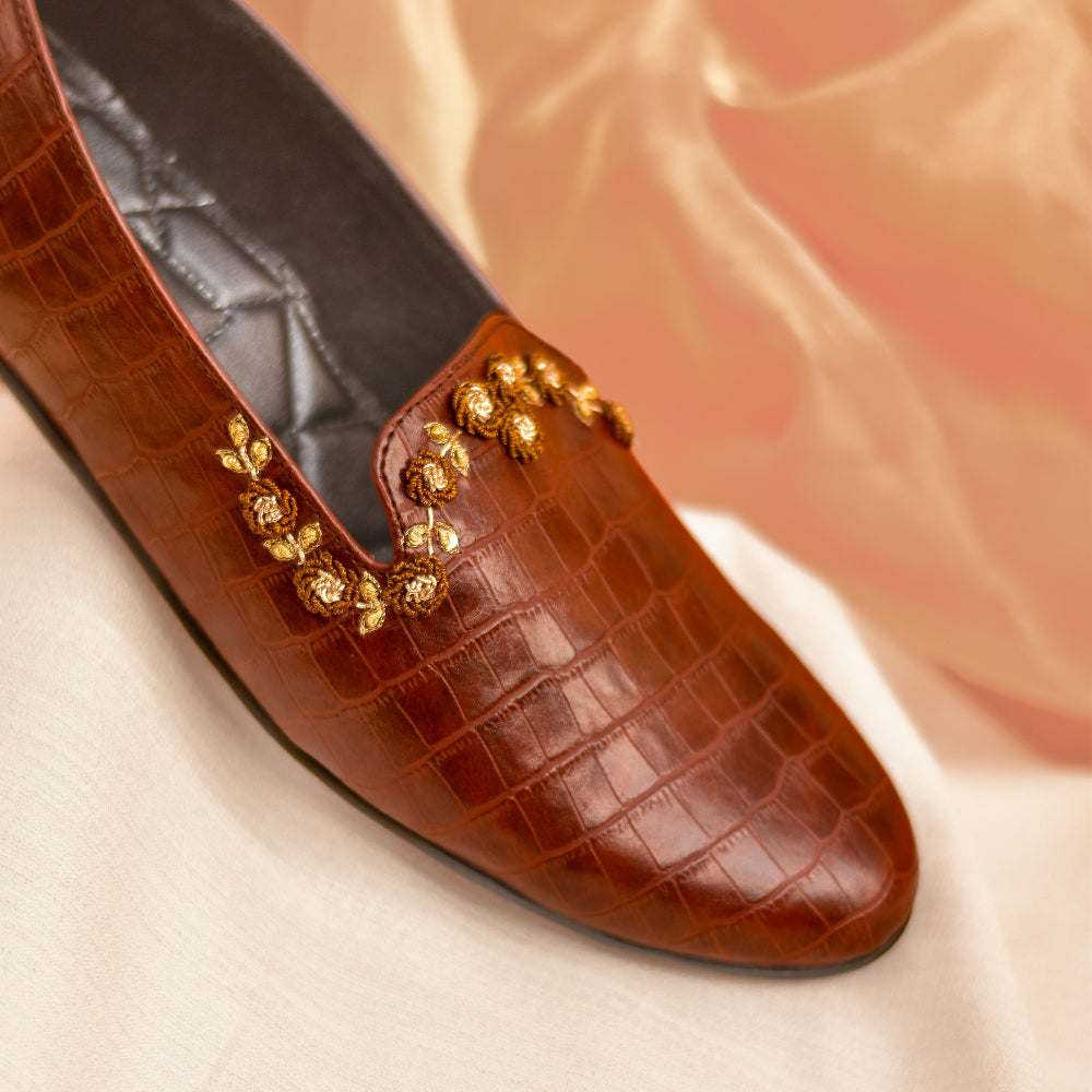 Structured brown loafer with detailed floral embellishment and comfortable cushioned base