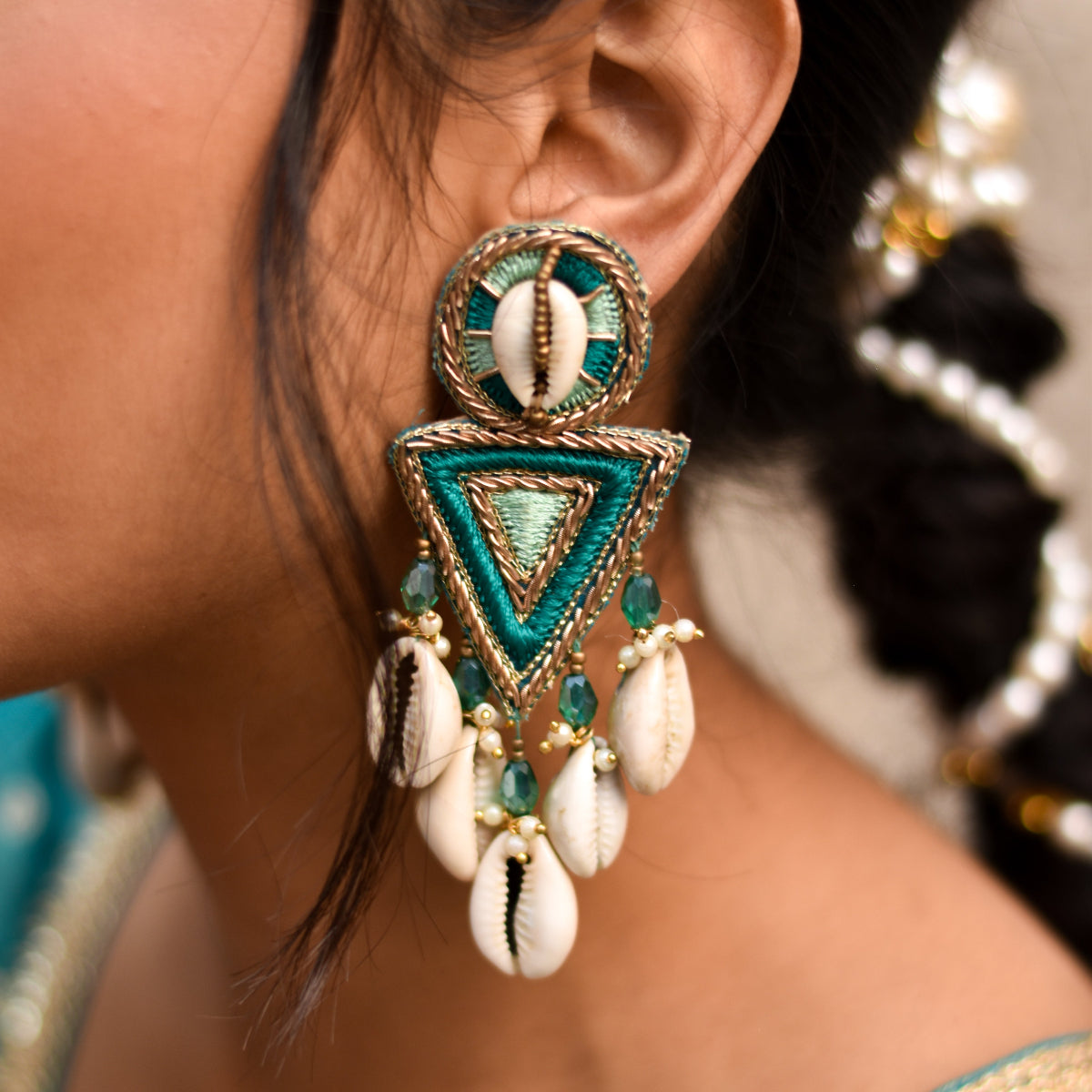 Statement earrings with cowrie shells and triangular thread design