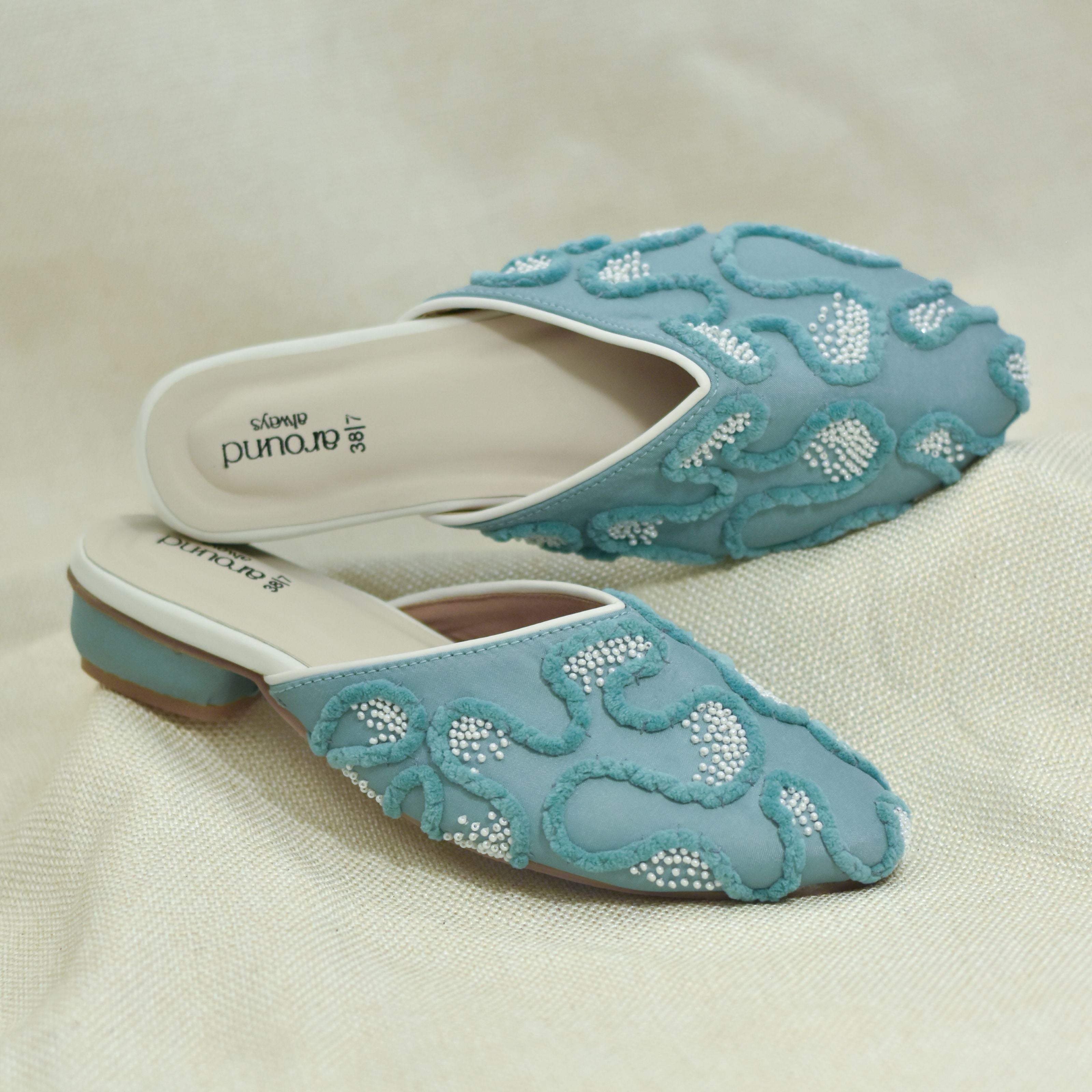 Teal blue slip-on mules with raised threadwork and bead accents
