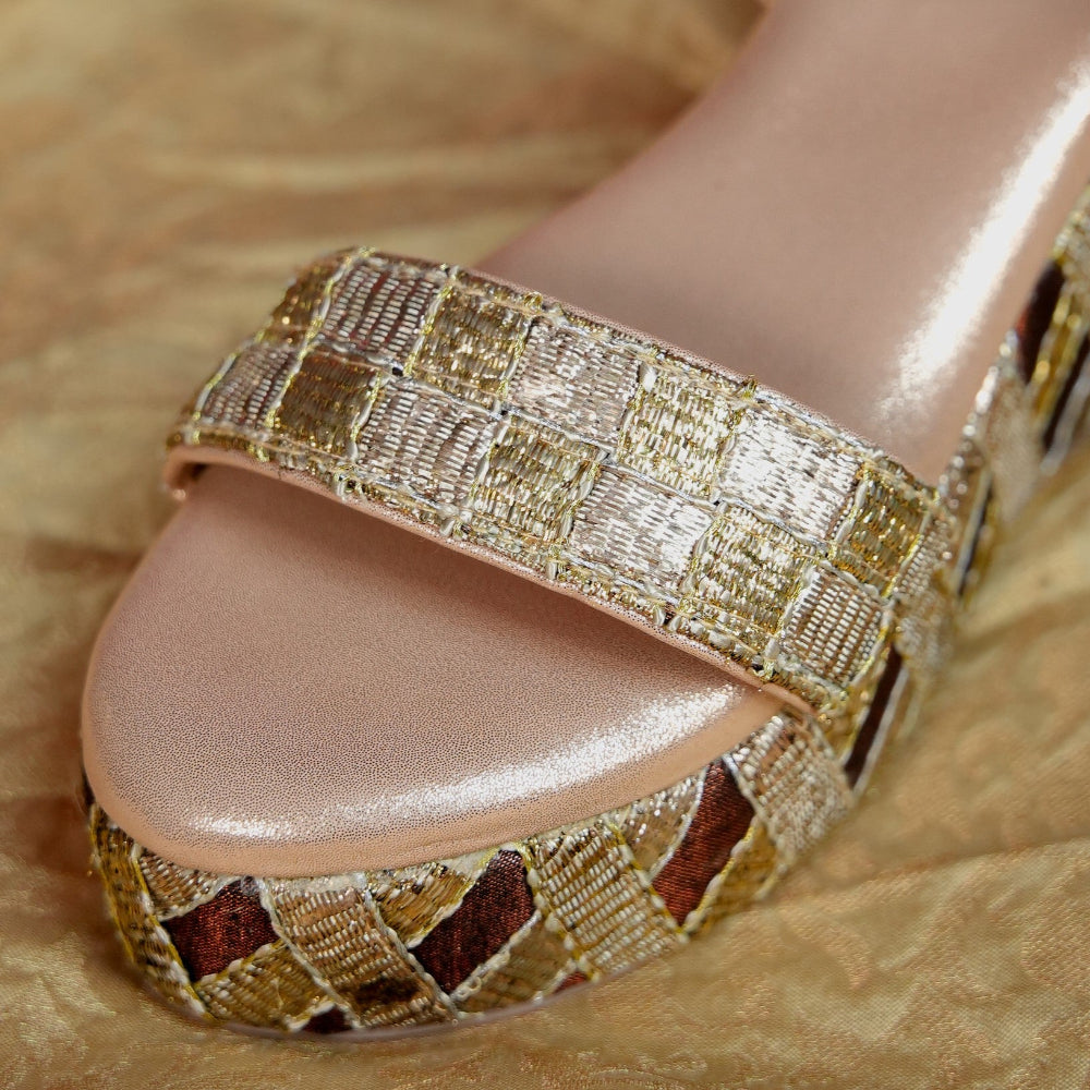 Festive champagne sandal with patterned platform base and ankle strap
