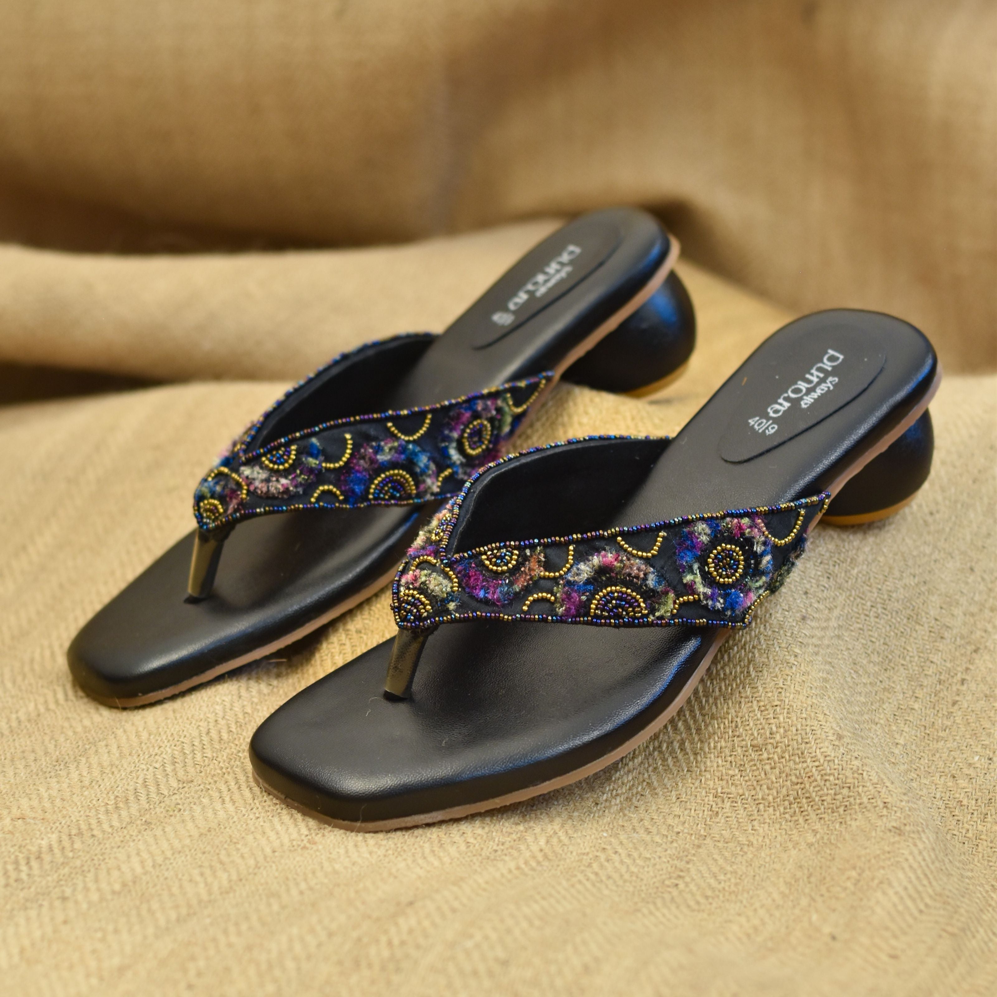 Hand-detailed open-toe footwear with bold thread accents and circular heel