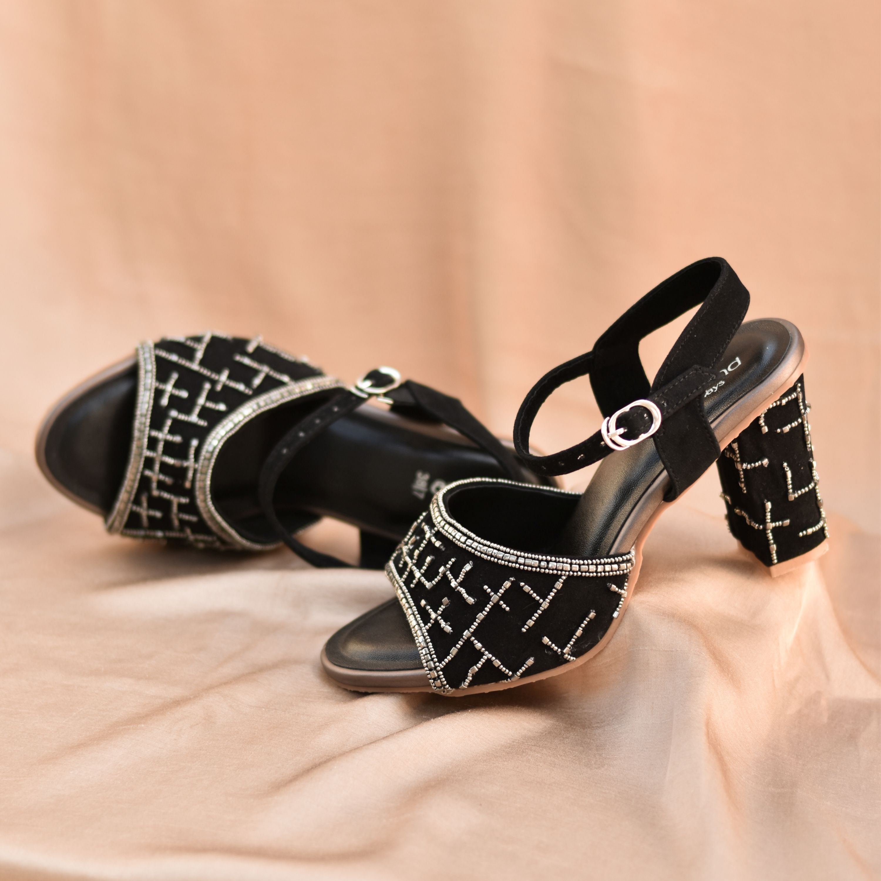 Black block heels with gunmetal beadwork and ankle strap.
