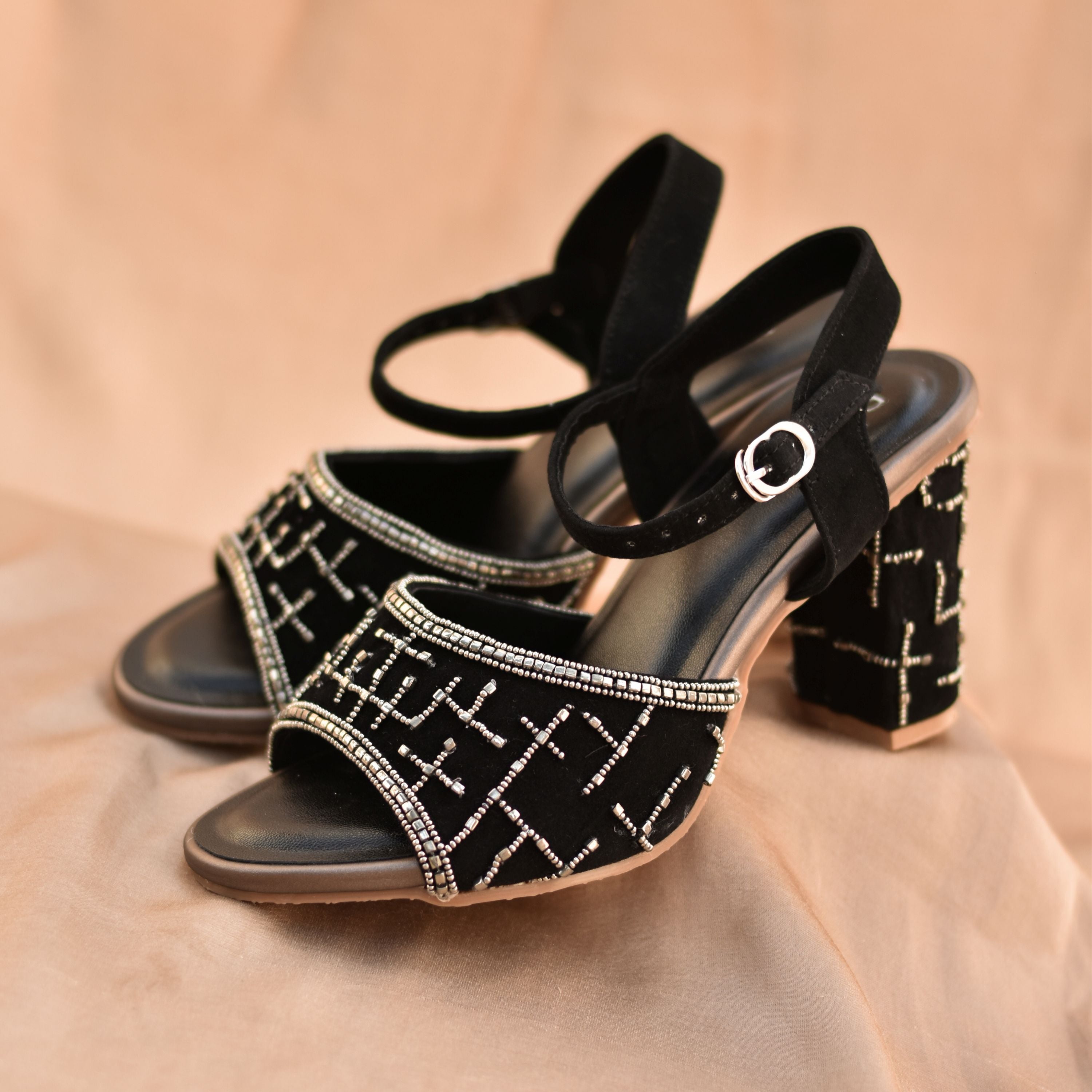 Suede black sandals with embellished block heel and open toe.