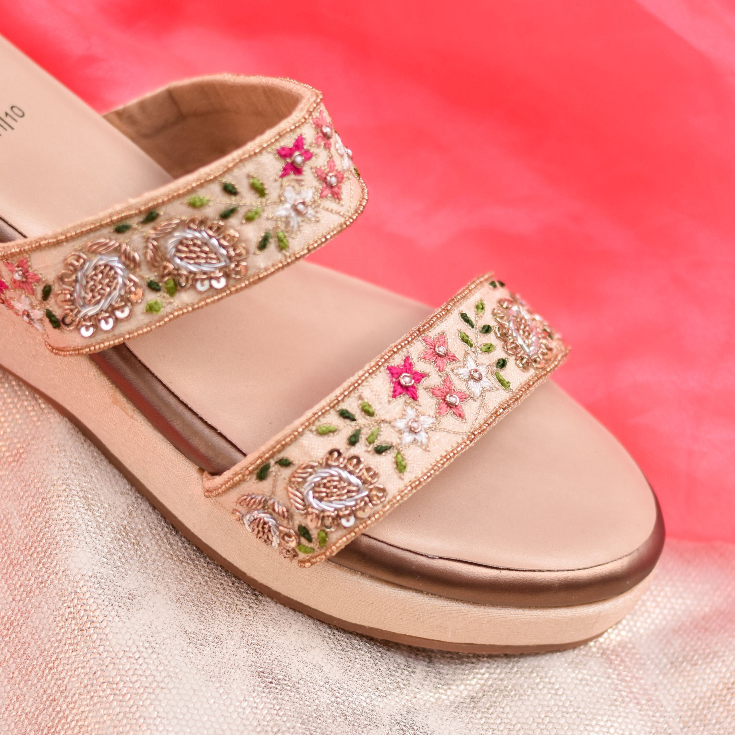 Twin-strap design featuring pink, peach, and green handcrafted embroidery.