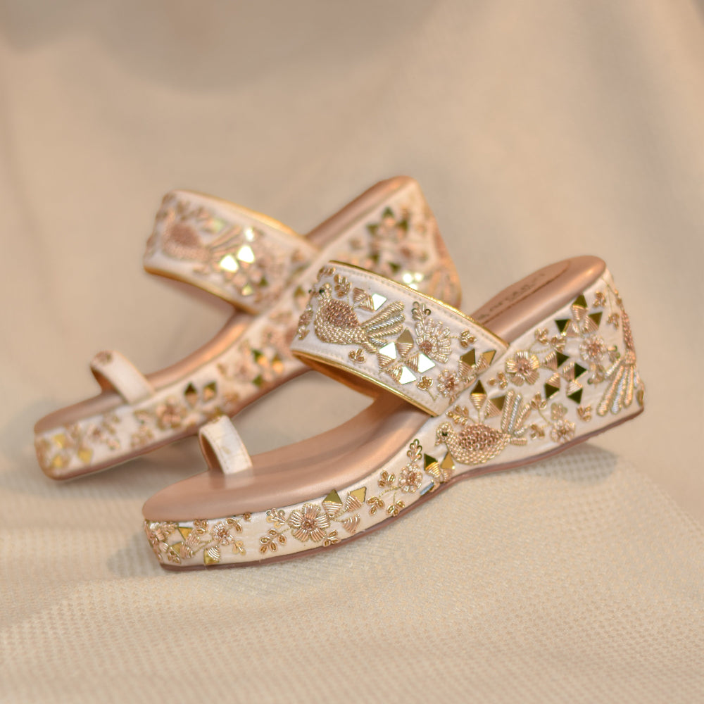 Hand-embroidered ivory wedge sandals featuring peacocks, florals and metallic threadwork
