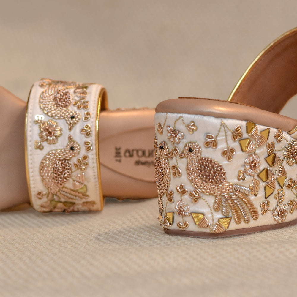 Ivory platform sandals with detailed bird motifs, mirror work and cushioned footbed
