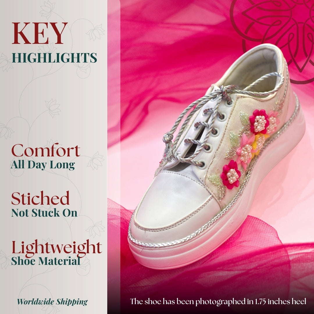 Silver lace up sneakers with embroidered pink floral motifs, cushioned sole, and lightweight design for all day comfort.