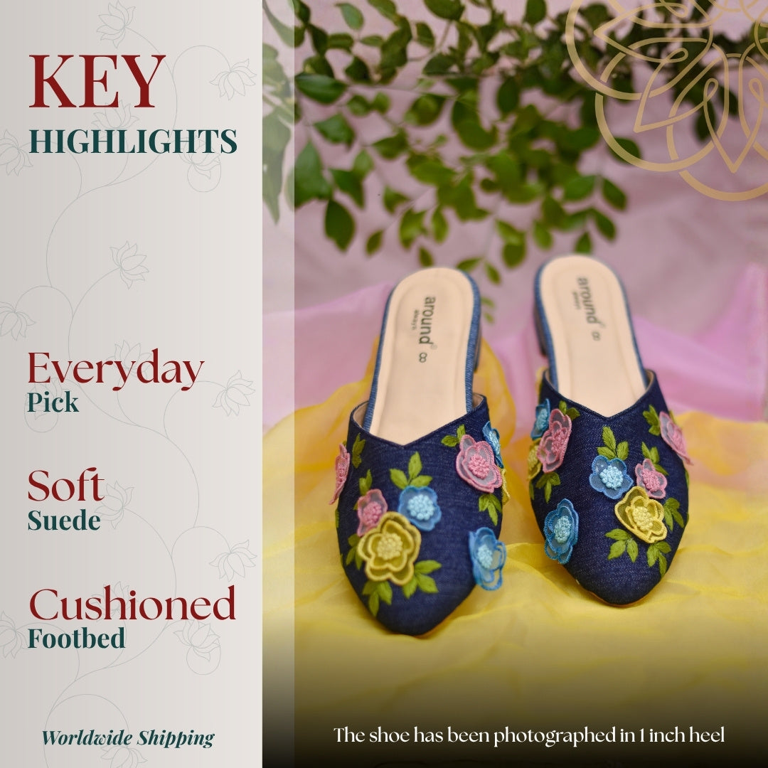 Blue denim mules with multicolor floral embroidery and pointed toe silhouette
