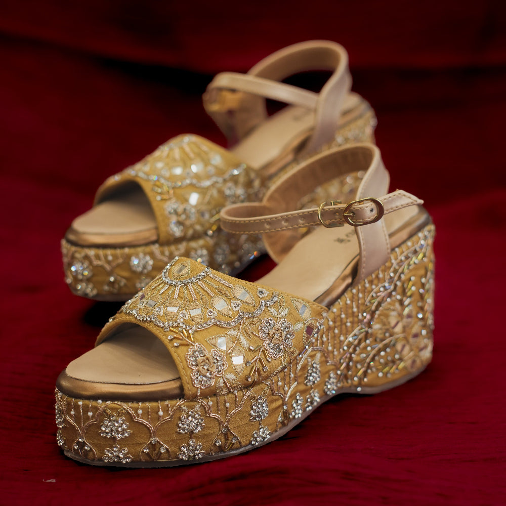 Gold embroidered wedge sandals with floral embellishments
