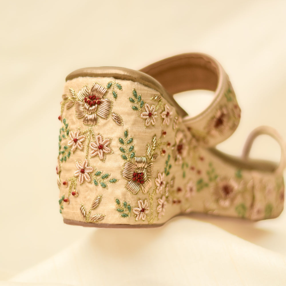 Designer Gold wedge heels featuring floral handwork.
