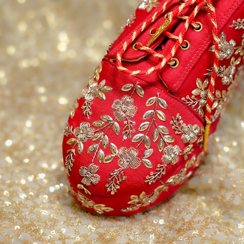 Festive red sneaker wedge enhanced with metallic threadwork and ornate floral craftsmanship