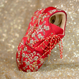 Handcrafted red bridal sneaker showcasing floral motifs and a lace-up design