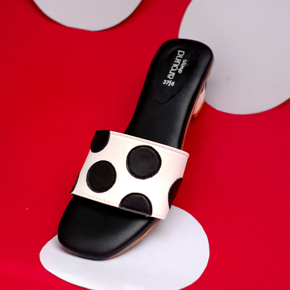 Black and white mule with circular appliqué details on front strap
