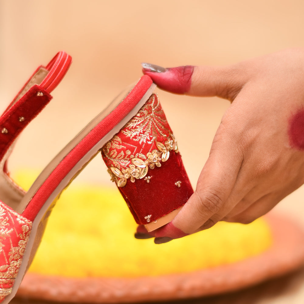 Close up of festive red sandal with sequin detailing and block heel
