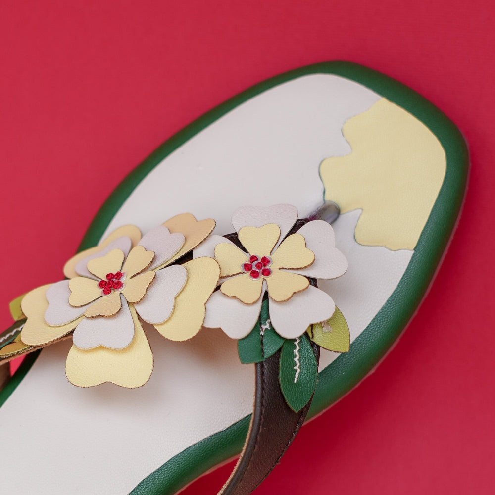 Floral flat sandal in ivory and green with layered blooms
