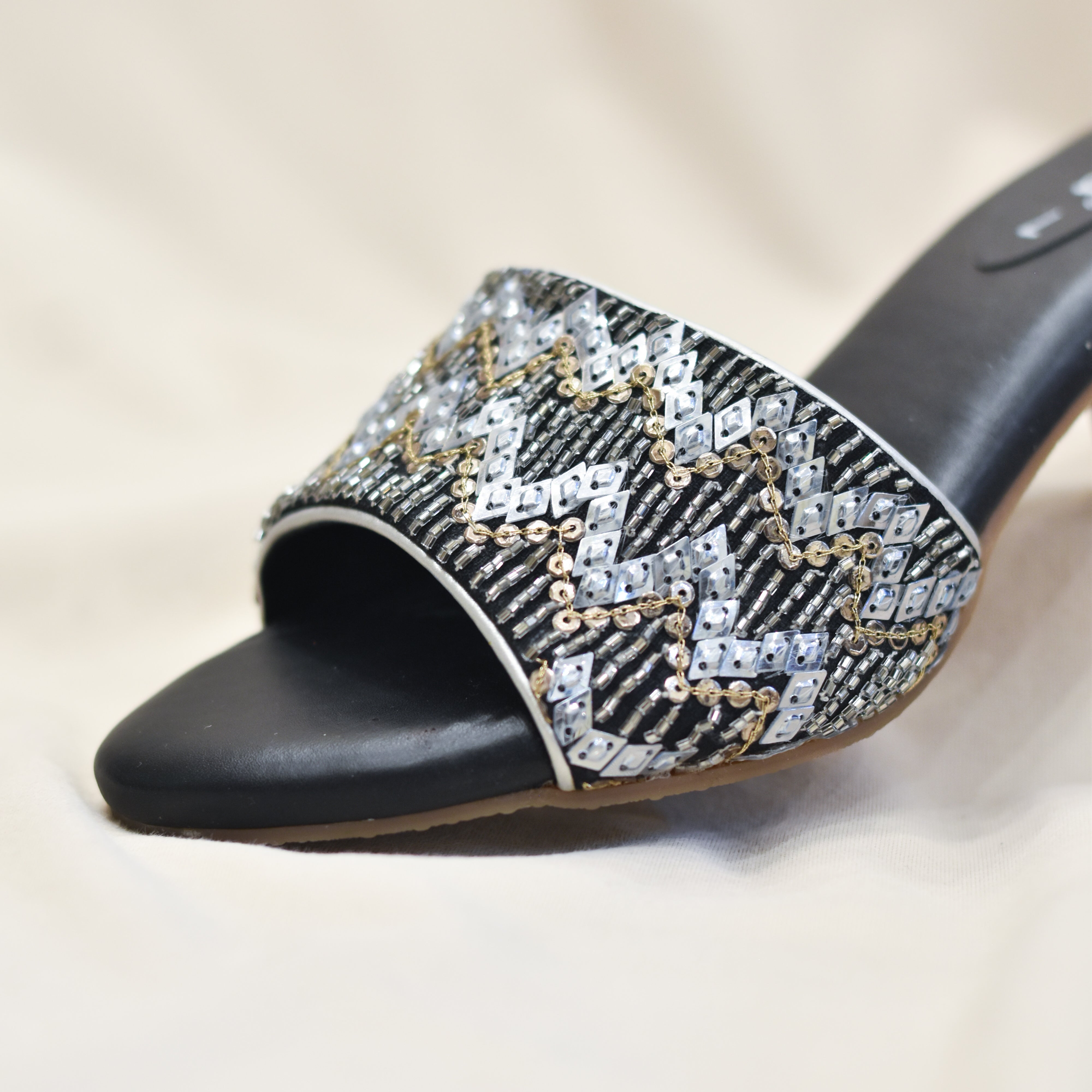 Festive black block heels with shimmering chevron pattern.