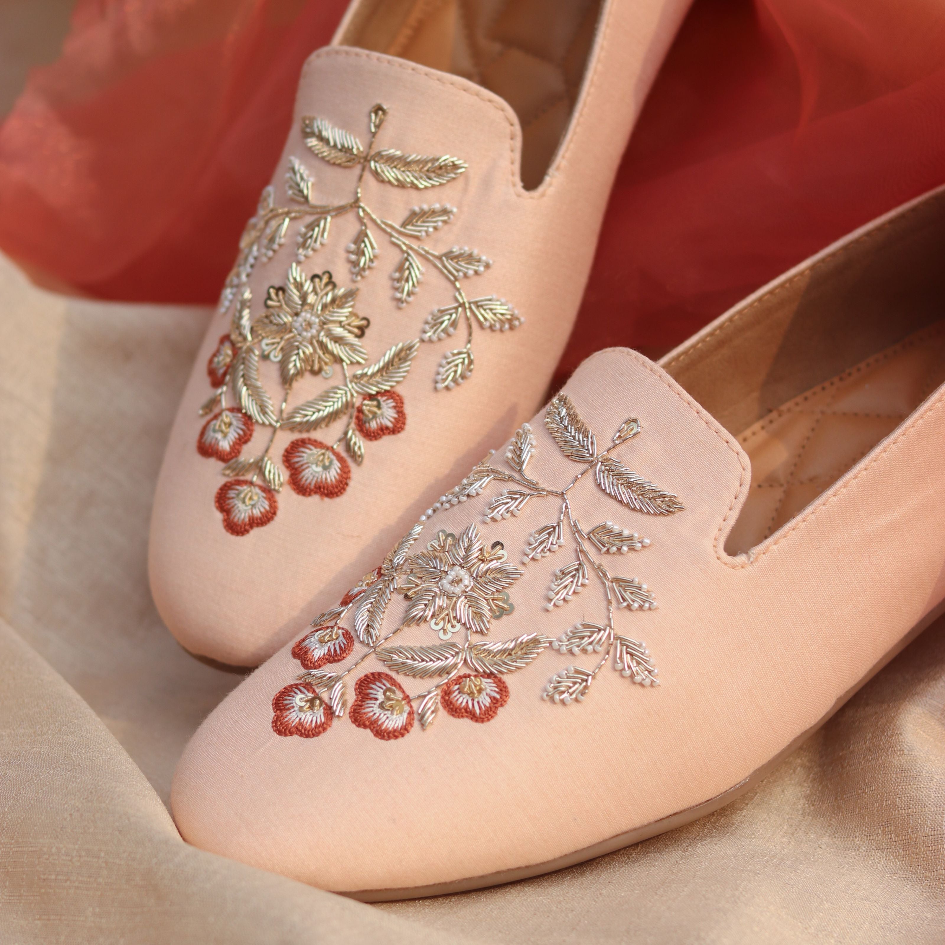 Blush-coloured men’s slip-on shoes with floral embroidery in antique gold and rust threads.