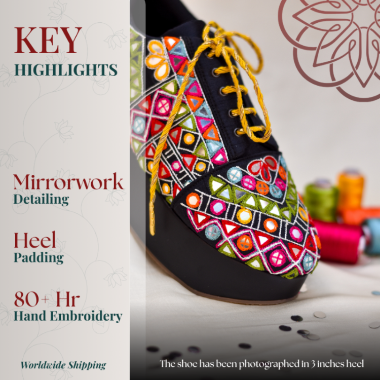 Black wedge sneaker with vibrant mirrorwork embroidery, gold laces, and cushioned heel support
