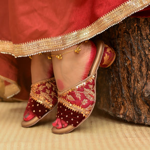 Traditional red and gold embroidered sandals with zardozi detailing.