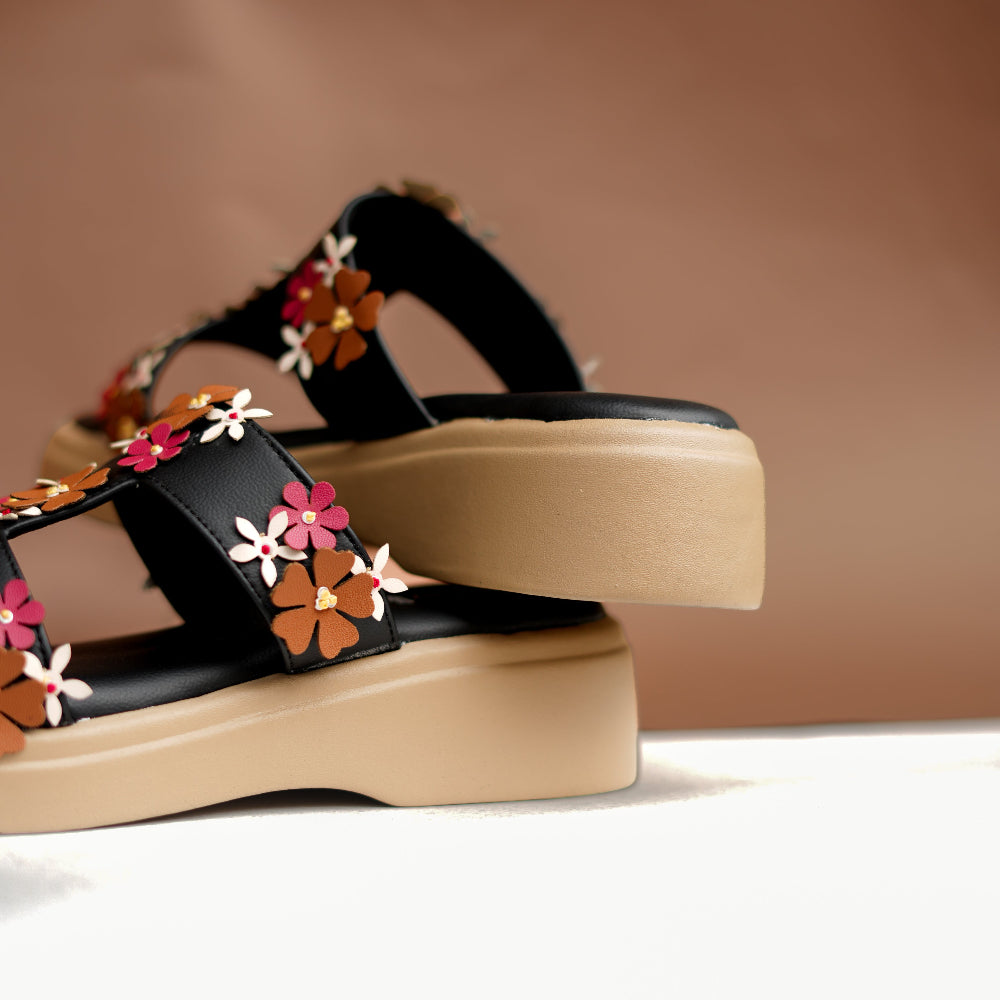 Multicolour flower appliqués arranged on a black platform sandal
