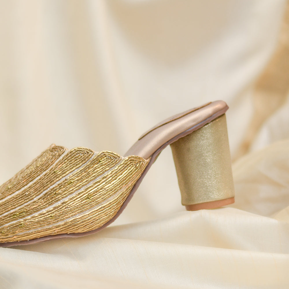 Elegant gold block heel mules with fine metallic detailing.
