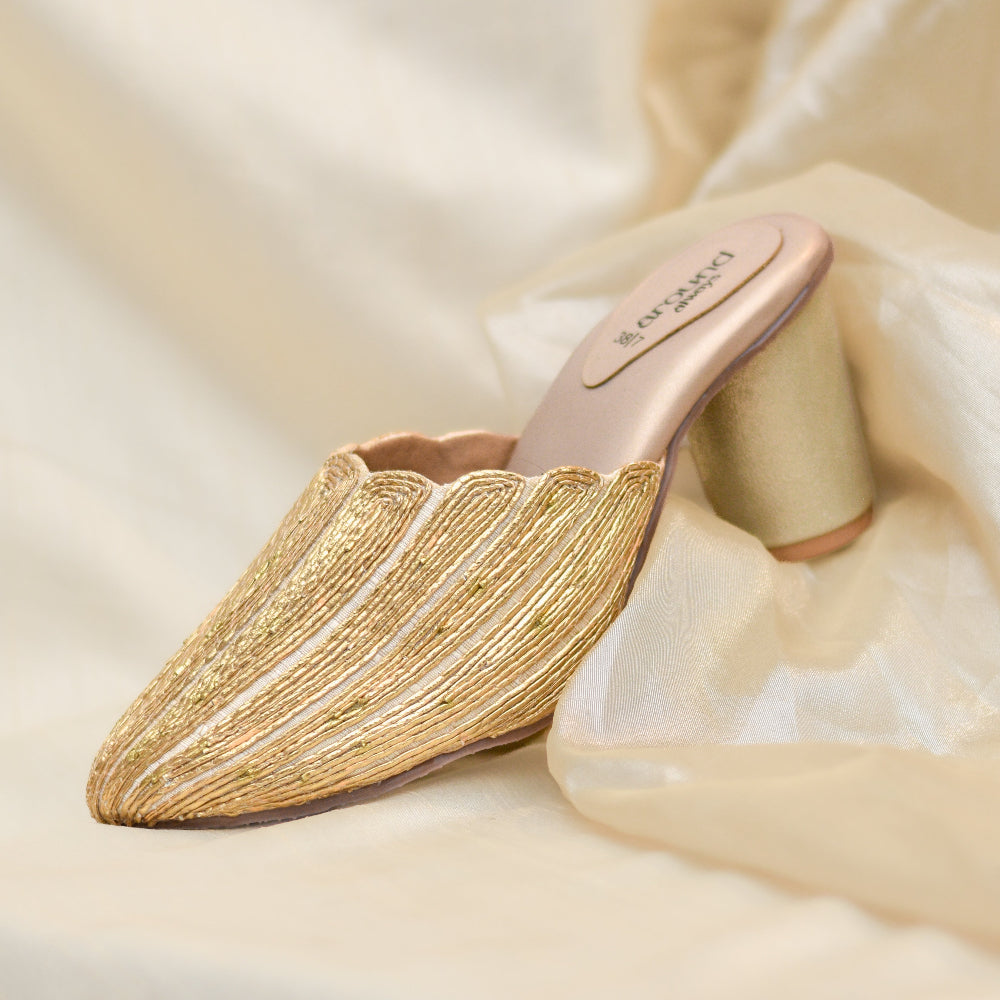 Gold pointed-toe mule block heels with metallic thread detailing.
