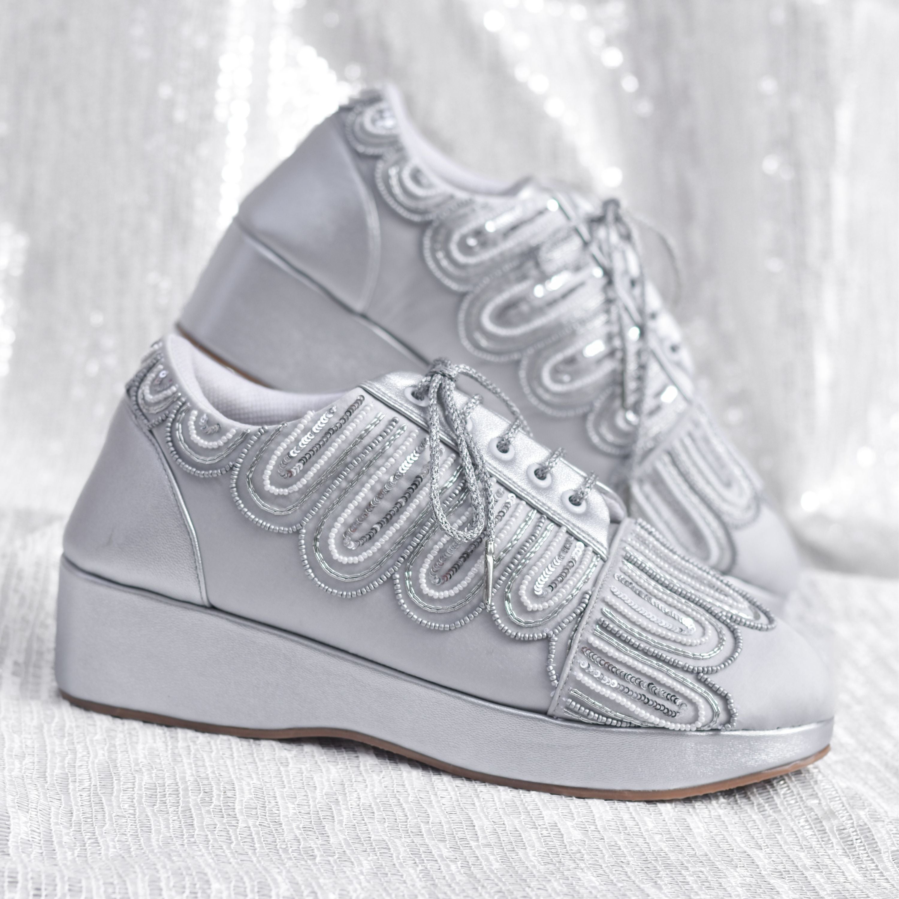 Silver bridal wedge sneakers with beaded embroidery.