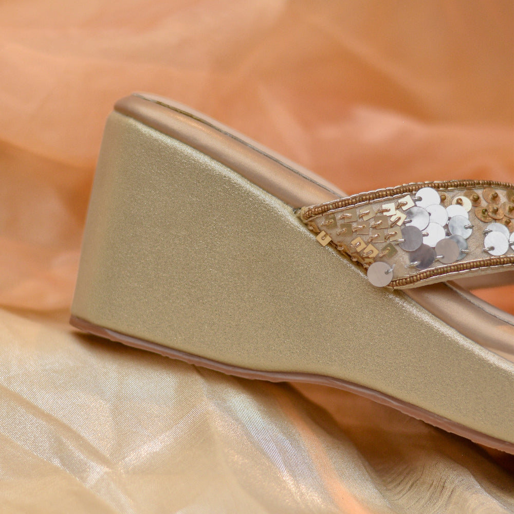 Ivory crossover wedge heels with metallic sequin handwork.

