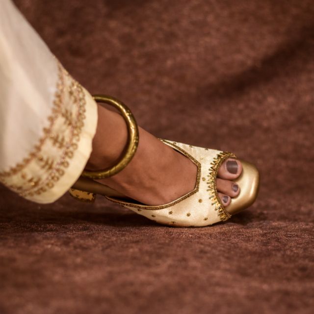 Gold sandal with intricate designs and stable heel