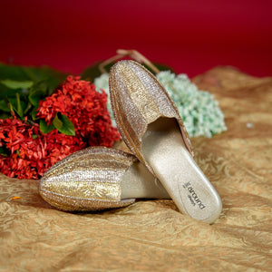 Metallic champagne mule featuring layered woven textile strips
