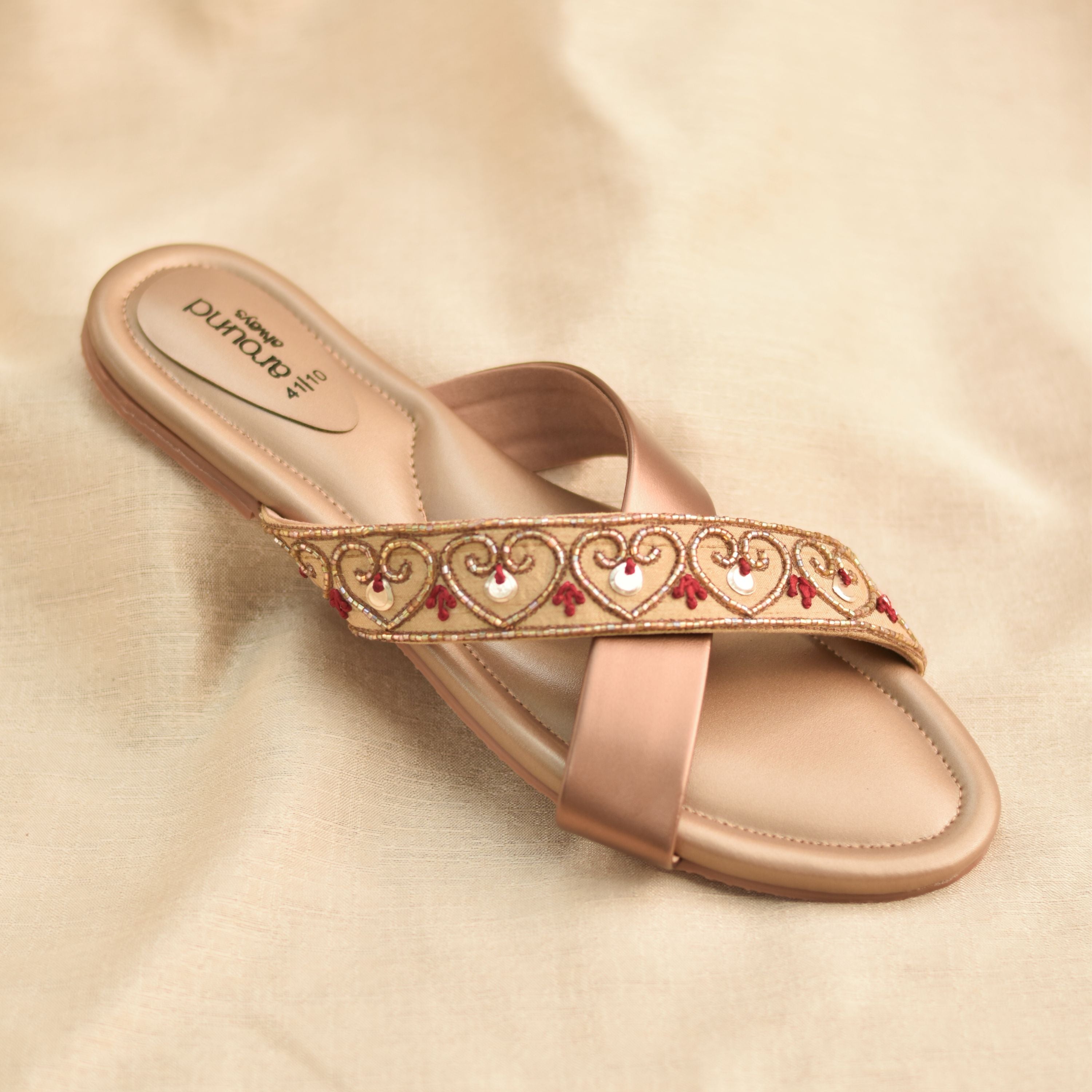 Golden-beige festive flats with heart-pattern embroidery and crossover design.