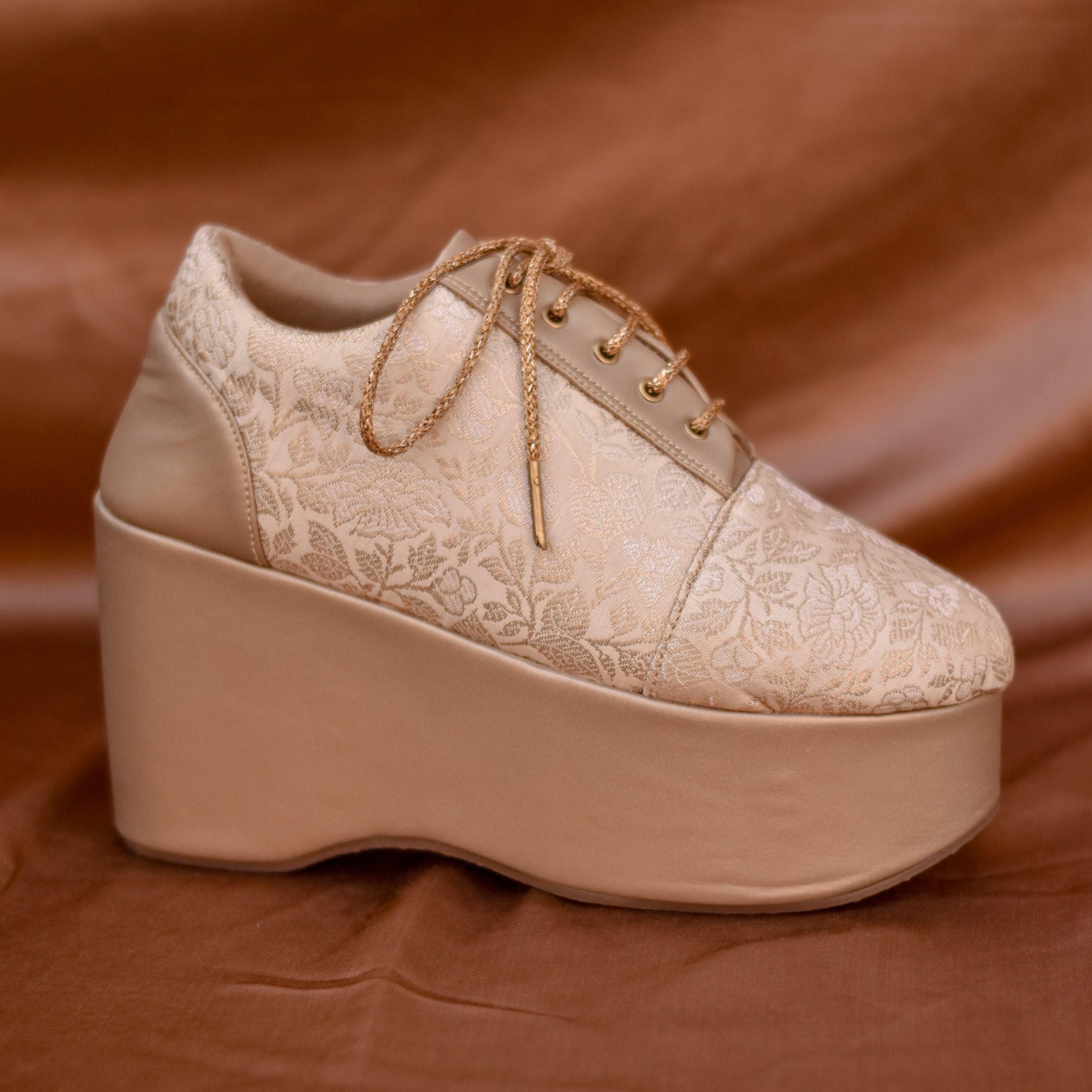 Designer bridal sneaker in gold with chunky wedge sole.
