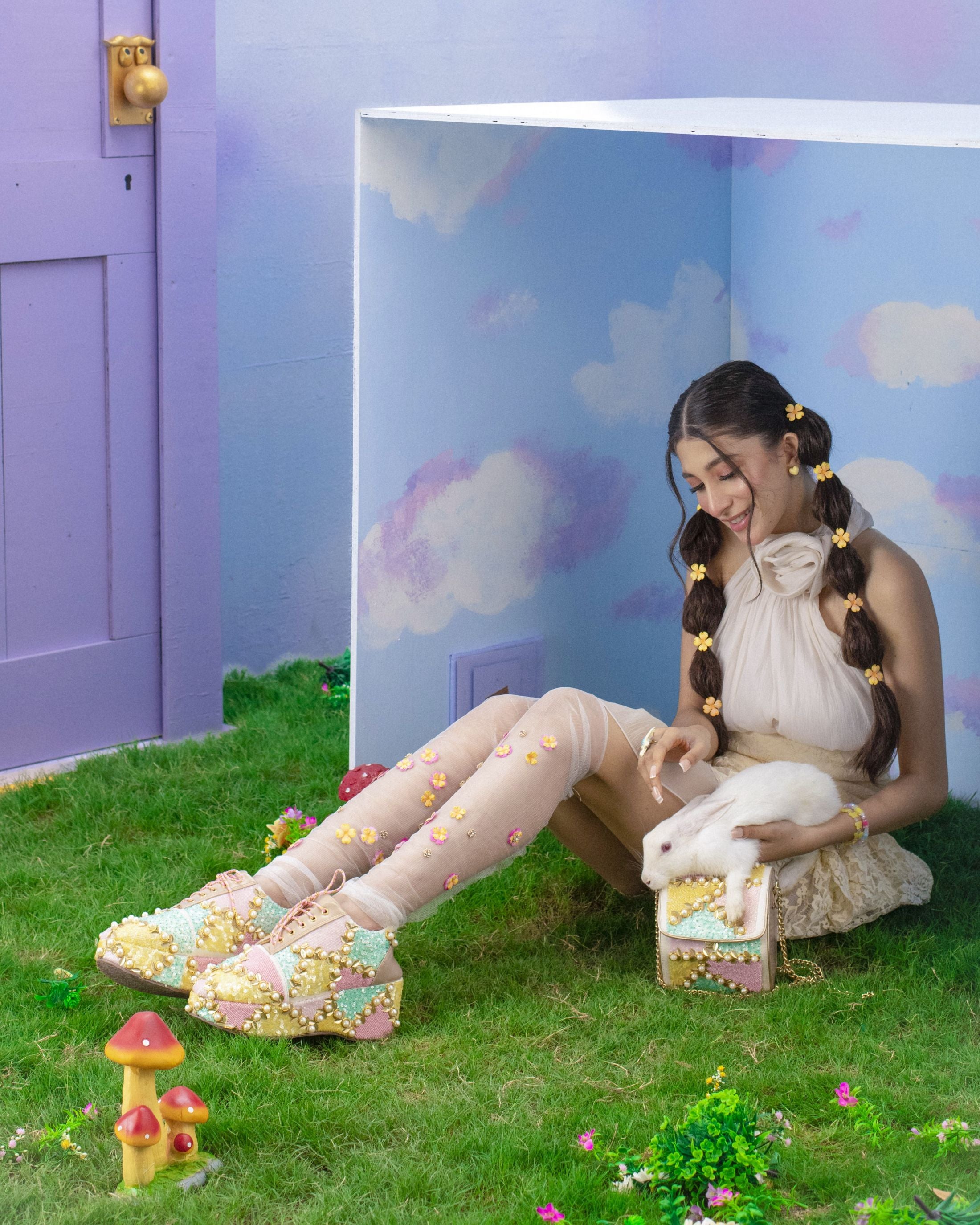 Women wearing multicolour platform shoes with bead details and dual-tone laces along with white bunny on grass.
